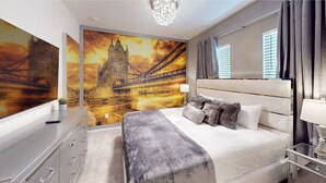 Un dormitorio moderno con una cama grande, una mesita de noche, un espejo y un mural en la pared de un puente.
