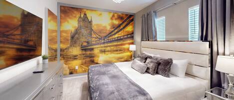 A modern bedroom with a large bed, a nightstand, a mirror, and a wall mural of a bridge.