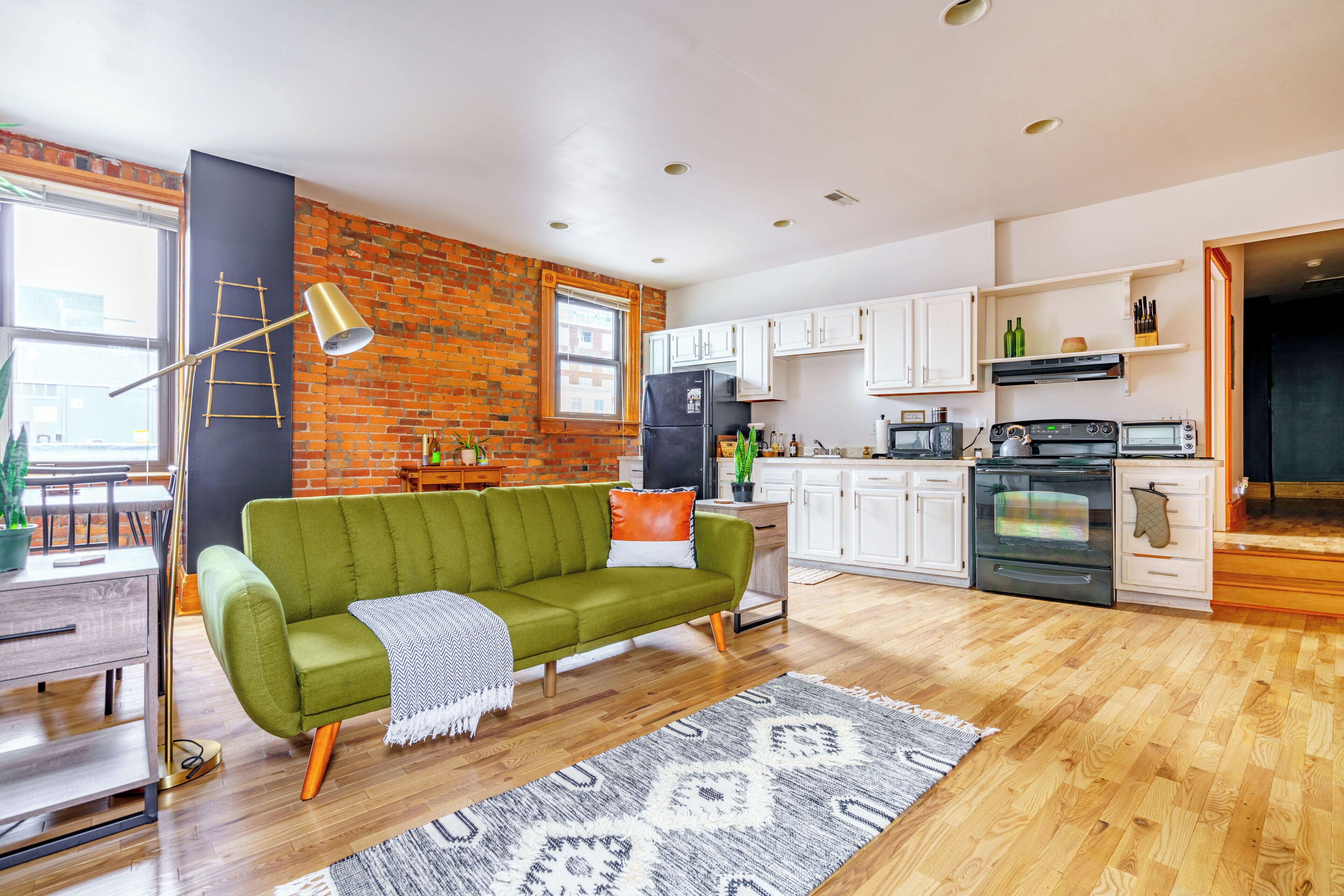 A modern kitchen with white cabinets, a refrigerator, and a microwave.