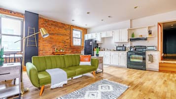 A modern kitchen with white cabinets, a refrigerator, and a microwave.