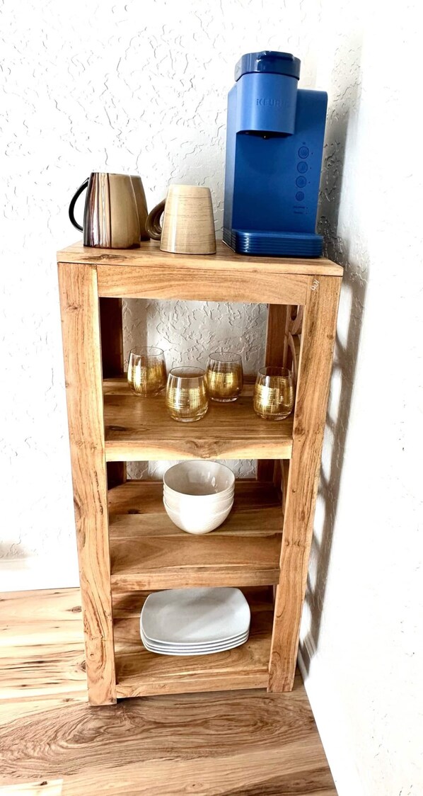 A wooden shelf unit with kitchenware and glassware. - University Suite "A" (Marion)