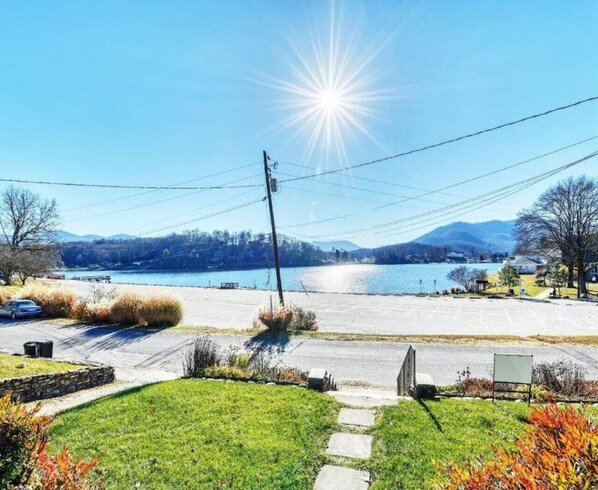 A parking lot with a view of a lake and mountains in the background.