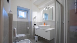 A modern bathroom with a toilet, sink, and shower.