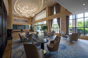 A spacious lobby with a high ceiling, seating area, and large windows.