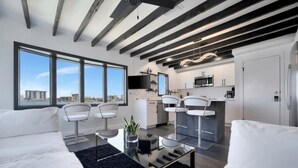 Studiosuite – design, 1 queensize-seng, utsikt mot bukt | Oppholdsområde | En 45-tommers smart-TV med digitale kanaler