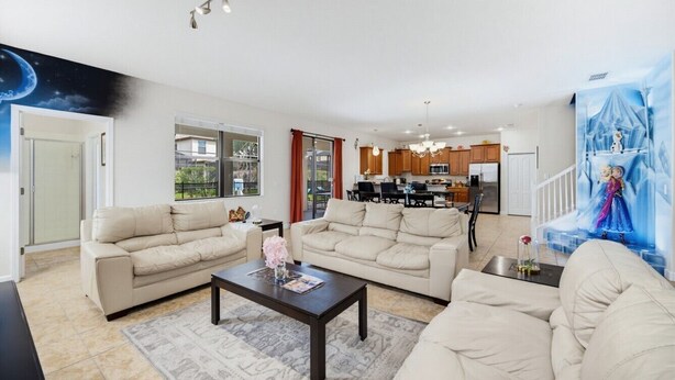 Een ruime woonkamer met twee banken, een salontafel en een keuken op de achtergrond.