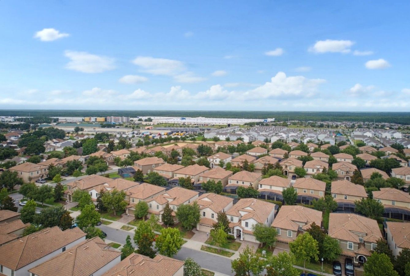 Ett bostadsområde med hus, gator och en avlägsen utsikt över en vattenyta.