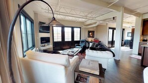 A spacious living area with a large window, a sofa, a coffee table, and a fireplace. - The Lincoln 501, 2 Bed / 2.5 Bath, Luxury Condo (Santa Fe)