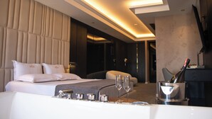 A modern hotel room with a large bed, a sitting area, a minibar, and a television. - Hotel Chicago (Shkodër)
