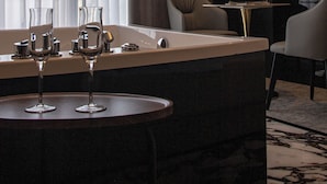 A modern hotel room with a bar area, a round table, and two chairs. - Hotel Chicago (Shkodër)