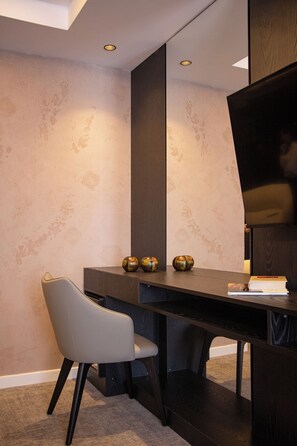 A modern room with a dark wooden desk, a grey chair, and decorative spheres.