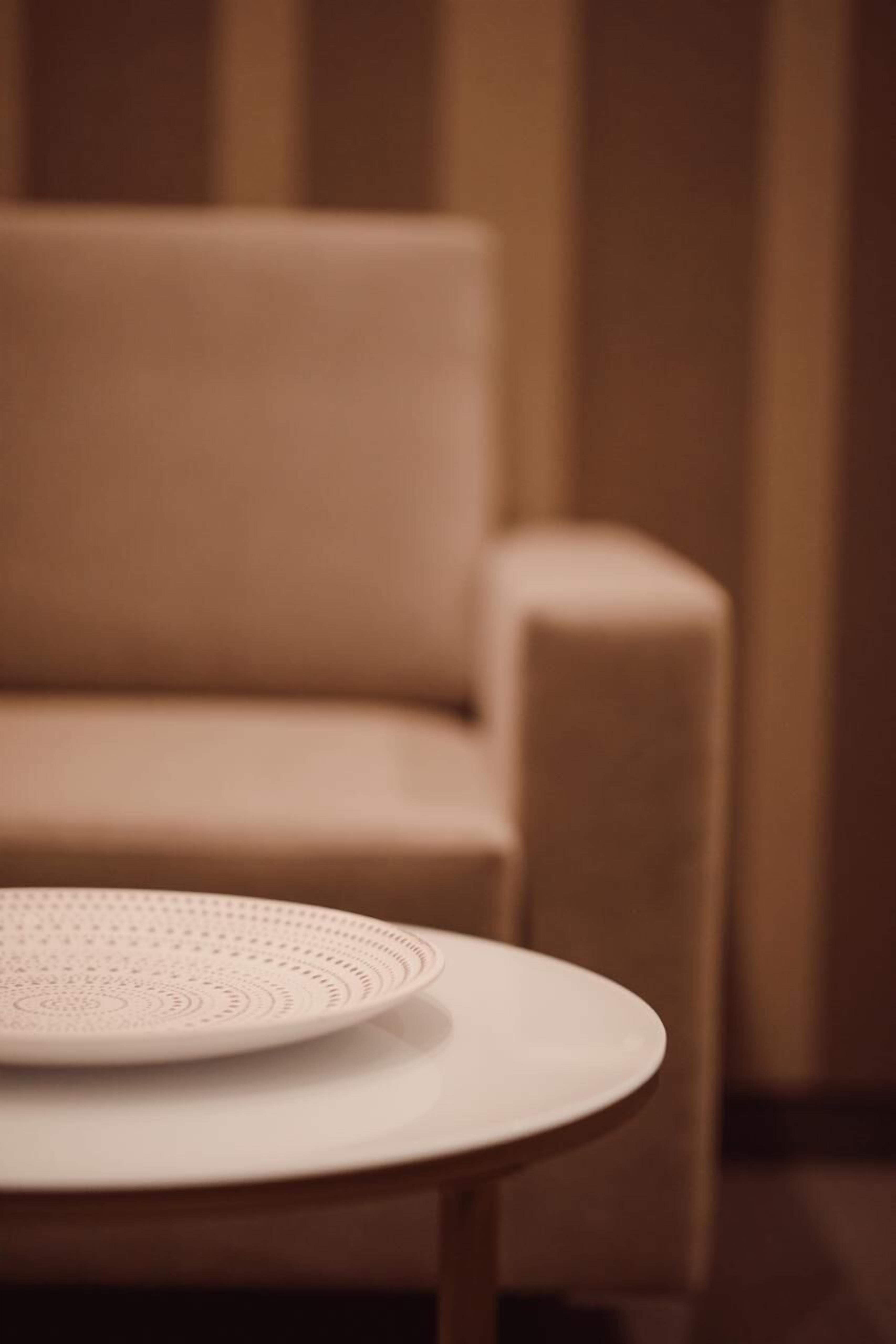 A round table with a white plate and a decorative item.