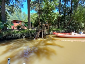 A wooden structure with a slide in a forested area. - Cabaña del humedal (Partido de Tigre)