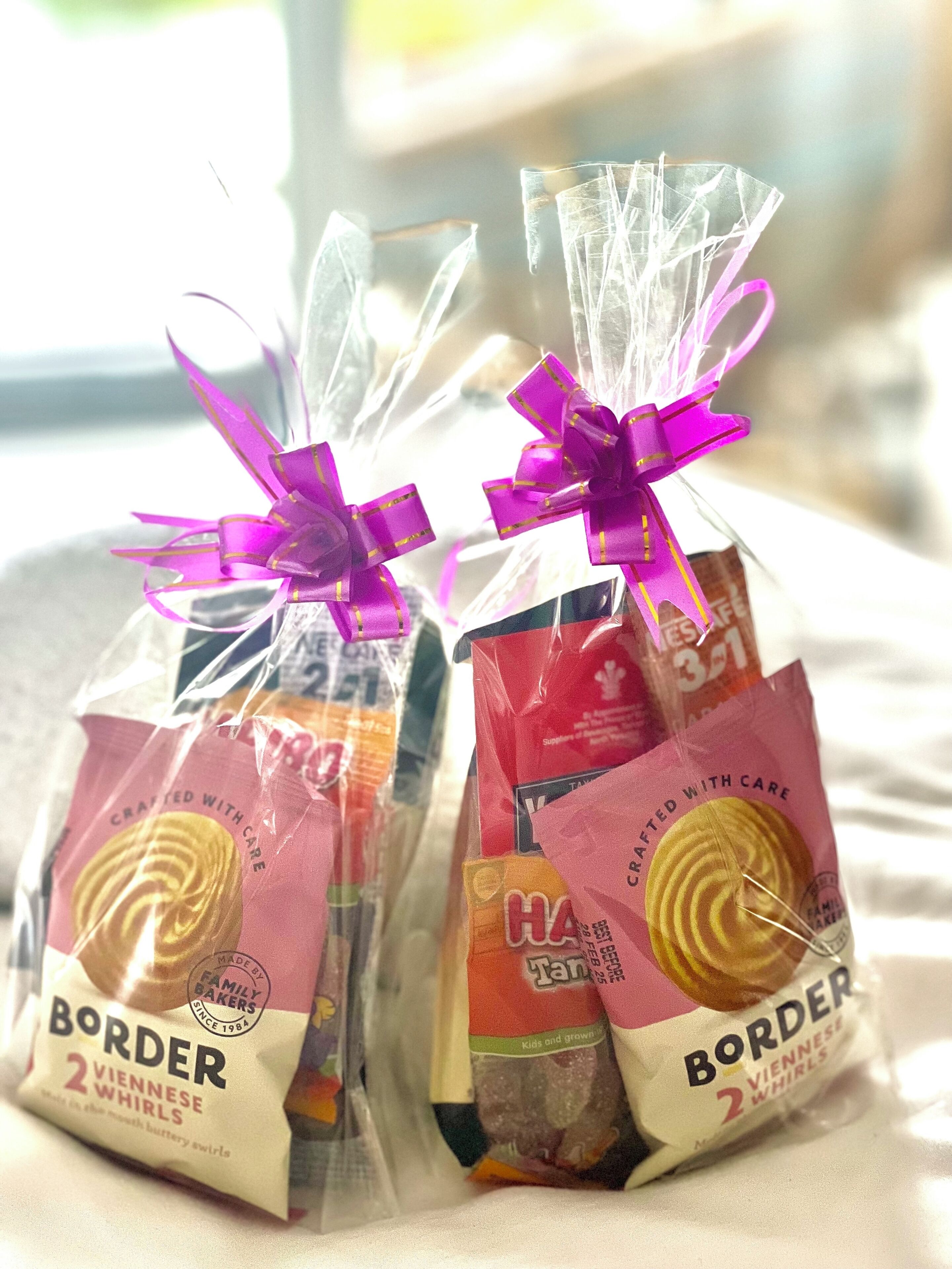 Two packages of Border Vienna Whirls cookies tied with purple ribbons.