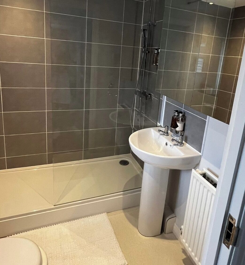 Un bagno con doccia, lavandino e toilette.