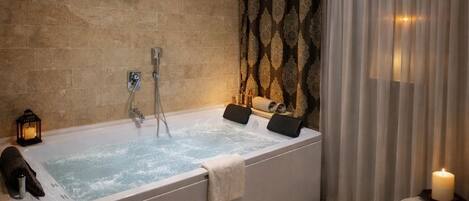 Un baño moderno con una bañera grande, ducha y tocador.