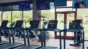 A gym with treadmills, stationary bikes, and elliptical machines.