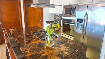 Deluxe Condo | Private kitchen | Full-sized fridge, microwave, oven, blender