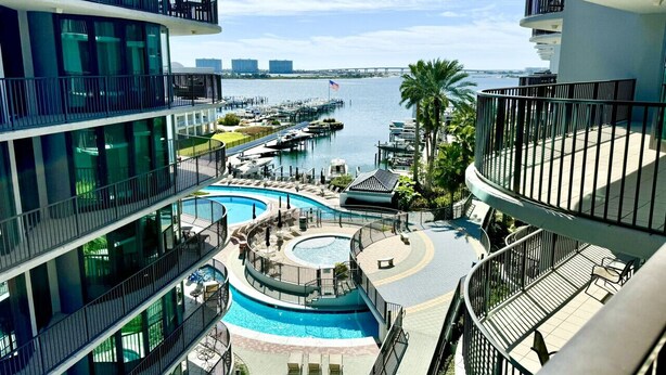 A multi-level hotel with balconies, a pool area, and a marina view. - Float The Stress Away & Enjoy The Lazy River. Pet Friendly Condo On 5th Floor (Orange Beach)