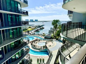 A multi-level hotel with balconies, a pool area, and a marina view. - Float The Stress Away & Enjoy The Lazy River. Pet Friendly Condo On 5th Floor (Orange Beach)