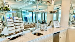 A modern kitchen with a large window, a ship model, and a dishwasher. - Float The Stress Away & Enjoy The Lazy River. Pet Friendly Condo On 5th Floor (Orange Beach)