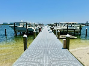 A pier leading to docked boats with a clear sky.