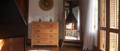 Una habitación acogedora con chimenea, cómoda de madera y un tapete redondo.