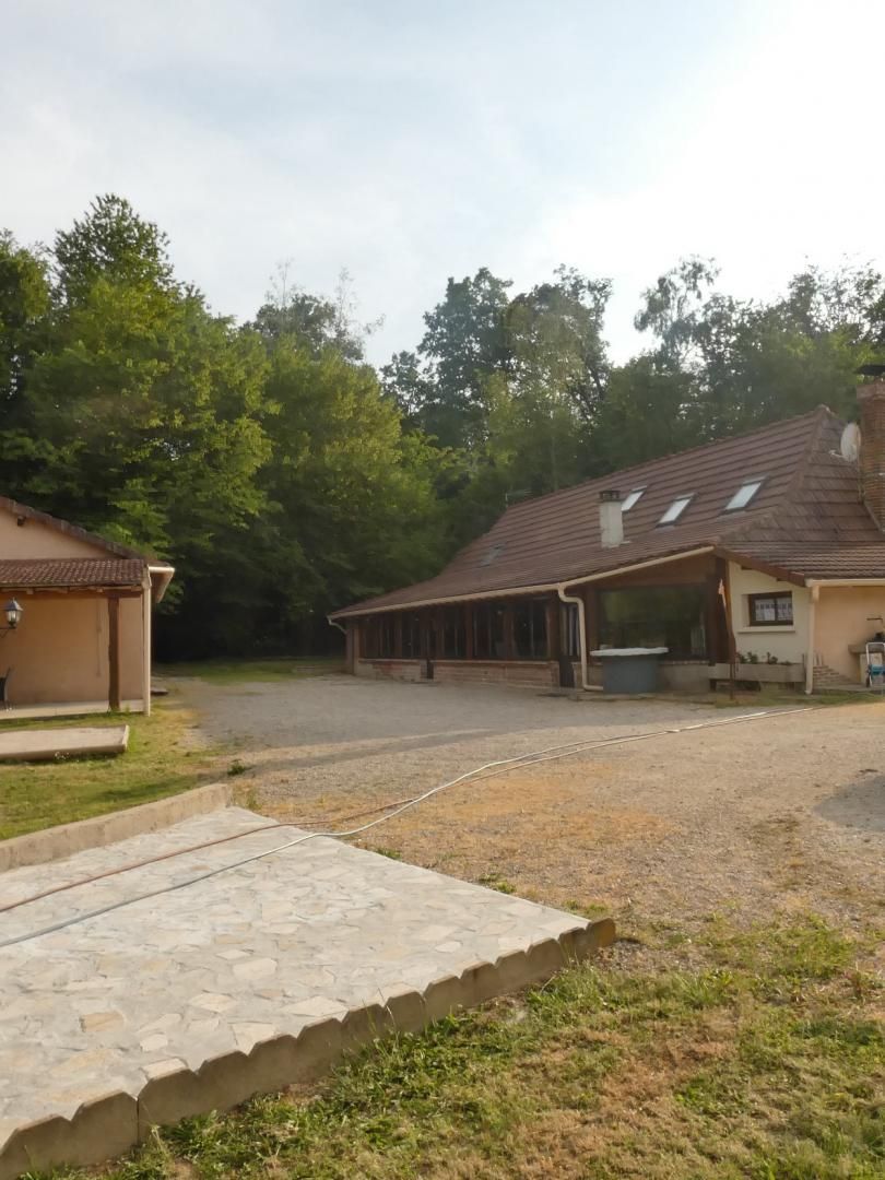 Un bâtiment doté d’un espace extérieur abrité, d’un chemin pavé et d’un parterre gazonné.