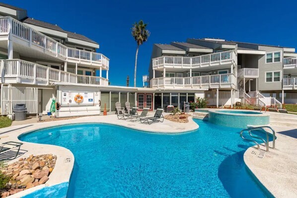 A swimming pool area with lounge chairs and a lifeguard stand.