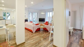 A modern, well-lit room with a bed, a dining area, and a TV. - Gorgeous apartment in San Bartolomeo di Leiv (San Bartolomeo di Leiv)