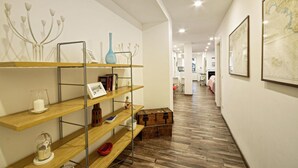 A hallway with wooden flooring, metal shelving units, and a framed map on the wall. - Gorgeous apartment in San Bartolomeo di Leiv (San Bartolomeo di Leiv)