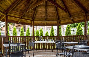 Relax in a serene garden setting with an outdoor seating area featuring tables and chairs.