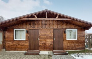 Stylish cabin with a symmetrical facade, featuring two large doors and a small porch area.
