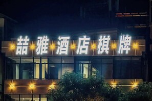 Placa de hotel com letras iluminadas.