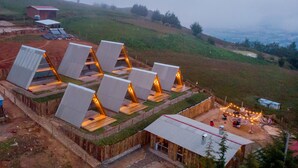 Un edificio moderno y ecológico con varias habitaciones que presentan tejados inclinados y estructuras de madera.