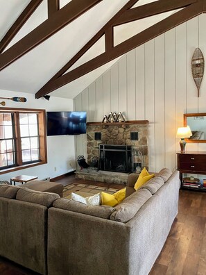 TV connectée, cheminée, livres, écrans d'ordinateur