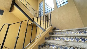 A staircase with a metal railing and patterned tiles. - Colmena Hotel CDMX Centro (Mexico City)