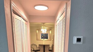 A hallway with wooden flooring, white walls, and closed louvered doors. - Alan's Apartment - Hot tub, fireplace, located in a quiet corner of Helen. (Helen)