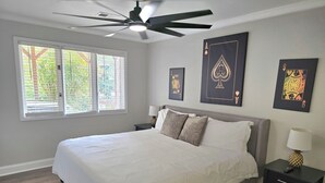 A bedroom with a bed, a ceiling fan, a window with blinds, and artwork on the walls. - Alan's Apartment - Hot tub, fireplace, located in a quiet corner of Helen. (Helen)