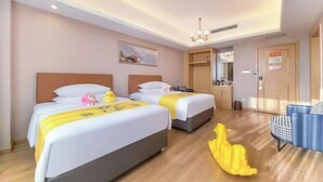 A hotel room with two beds, a desk, a chair, and a small sofa. - Vienna International Hotel (Xinhua)