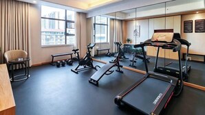 A gym with treadmills, stationary bikes, and weights. - Vienna International Hotel (Xinhua)
