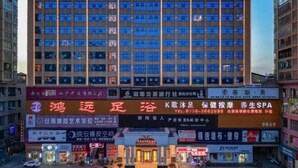 A multi-story hotel with a prominent sign at the top. - Vienna International Hotel (Xinhua)