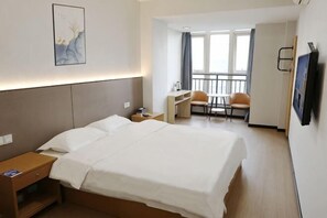 A hotel room with a bed, bedside table, desk, chair, and a view of the outside. - 998 Business Hotel (Chongqing)
