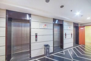 A modern elevator area with metallic walls and a patterned floor. - 998 Business Hotel (Chongqing)