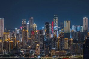 A nighttime cityscape with a dense cluster of high-rise buildings. - 998 Business Hotel (Chongqing)