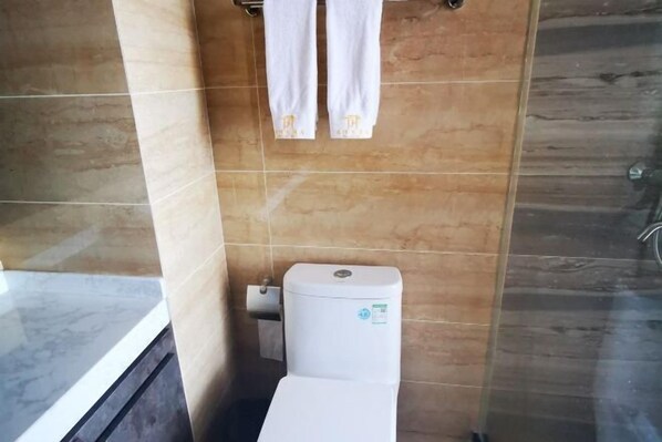 Un baño con inodoro, toallero y zona de ducha.
