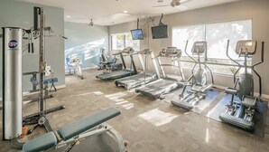 A gym with treadmills, elliptical machines, and weightlifting equipment.