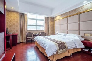 Habitación de hotel con una cama grande, un escritorio y una silla.