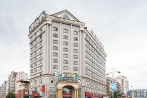 A multi-story hotel with a prominent entrance, large windows, and a classic architectural design. - Garden Hotel (Jiangle)