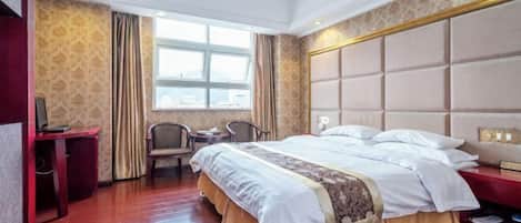 Una habitación de hotel con una cama grande, un escritorio, una silla y una ventana con cortinas.